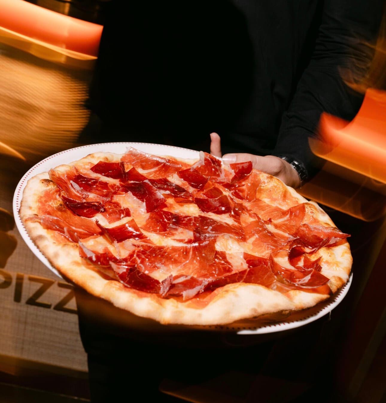 A pizza being served at the table